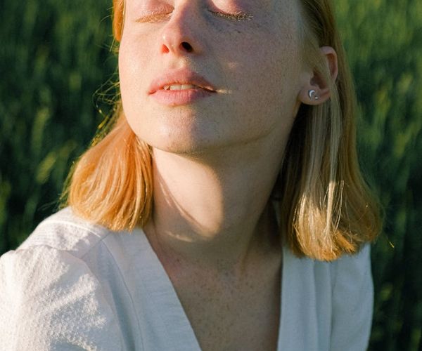 Close-up on a person's calm face with eyes closed during a breathing exercise.