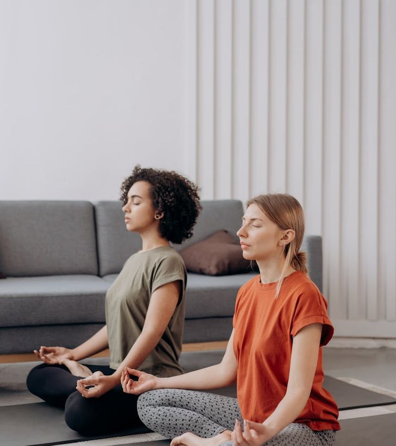 Person sitting comfortably and practicing a breathing technique in a calm room.