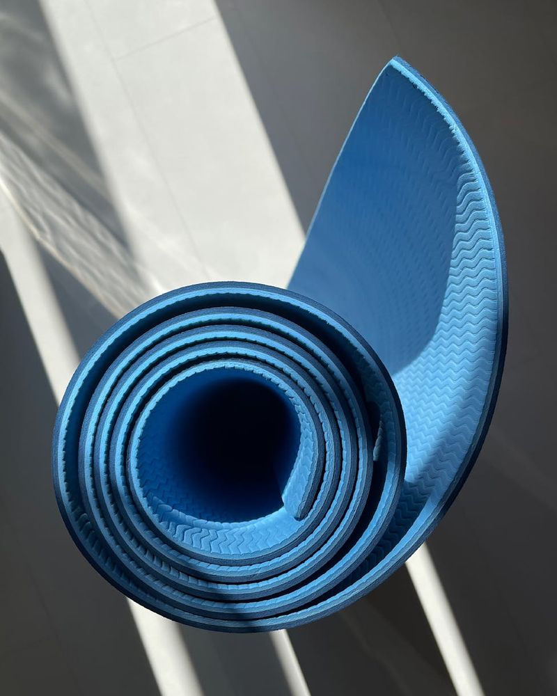 Spacious, bright room with a yoga mat on the floor, ready for practice.